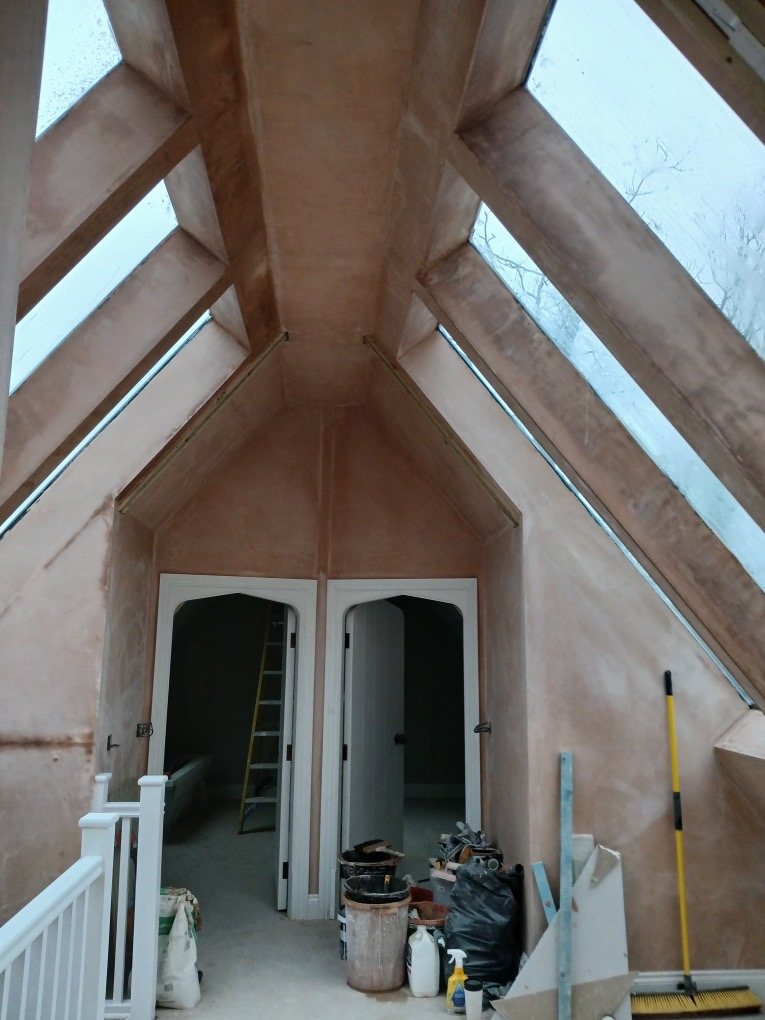 Freshly plastered vaulted room with glazed roof panels and two arched doorways